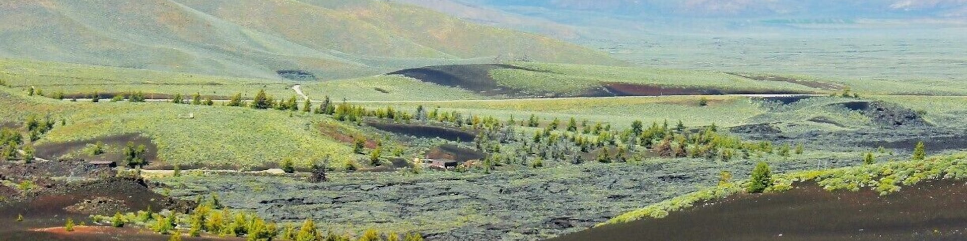 This is Craters of the Moon from the view atop Inferno Cone. A lot of contrast going on here with life springing from the ashes of lava tubes and spatter cones all atop a series of caves and tunnels to explore.
I'd say go before July or the heat reflecting off the Obsidian may be too much to handle. If you come after that... run to the caves where it will be 15 - 20 degrees cooler.
Ooh, one last tip if you're camping in the campground try to get site #13. It's super private and makes you feel like you're in a crater. Otherwise try to book the group site as it's the only one that will allow a proper fire. :)