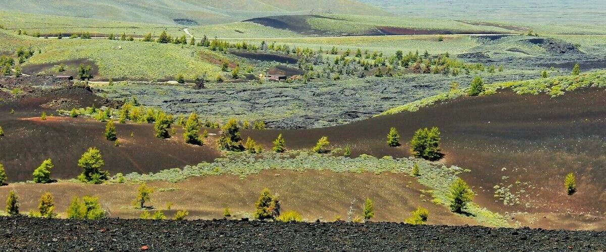 This is Craters of the Moon from the view atop Inferno Cone. A lot of contrast going on here with life springing from the ashes of lava tubes and spatter cones all atop a series of caves and tunnels to explore.
I'd say go before July or the heat reflecting off the Obsidian may be too much to handle. If you come after that... run to the caves where it will be 15 - 20 degrees cooler.
Ooh, one last tip if you're camping in the campground try to get site #13. It's super private and makes you feel like you're in a crater. Otherwise try to book the group site as it's the only one that will allow a proper fire. :)