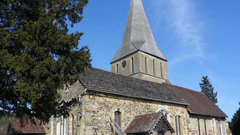 A church with a tall steeple and a stone facade.
