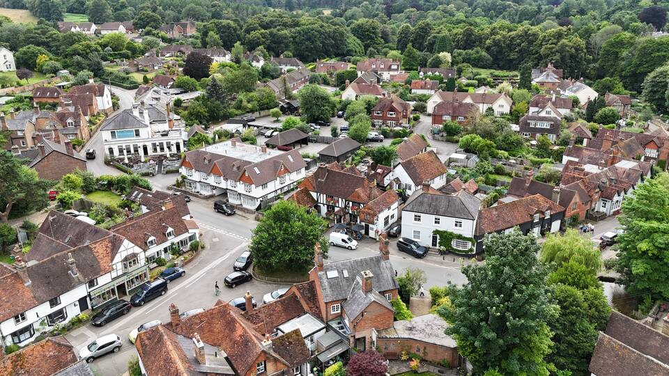 A historic village with traditional architecture, narrow streets, and lush greenery.