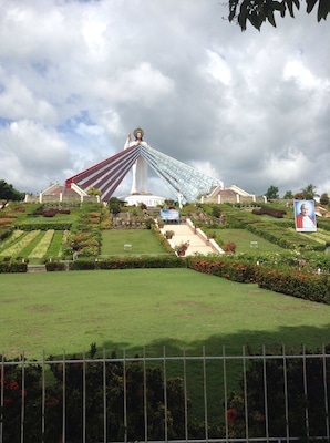This is the Divine Mercy Shrine in El Salvador City, Misamis Oriental, Philippines. It is a 9 hectare land and  has a 50 ft statue of divine mercy Jesus. When you are in the bottom of the entrance, you will see many steps, which has a total of 200 steps up to the top that is also an overlooking of Macajalar Bay. First, before you proceed in steps, you have to borrow a long skirt in the counter to show respect to the Divine Mercy. When you reach the top, you will be given an orientation in what to do/not to do when you go the top of the Divine Mercy Statue. You can buy souvenirs and can get water from the sink on which you will pray first. This is such a wonderful place. ❤️