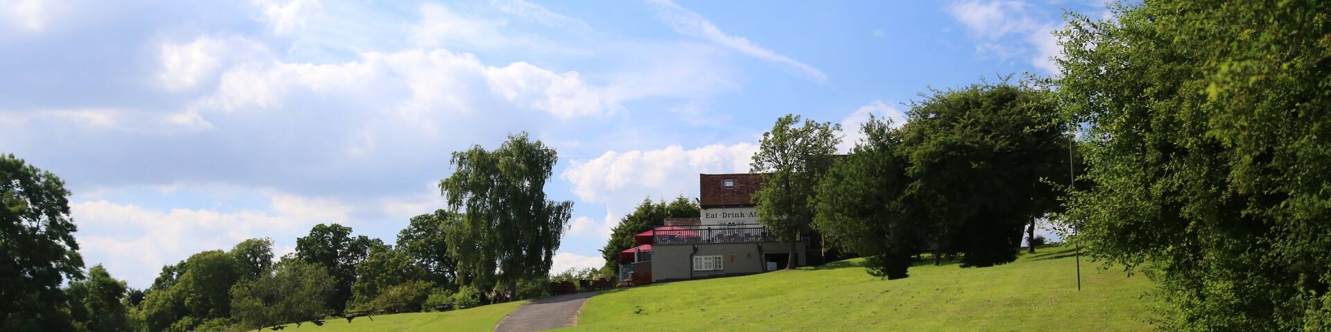 A grassy hill with a building labeled "Café Drink Ave" in the background.
