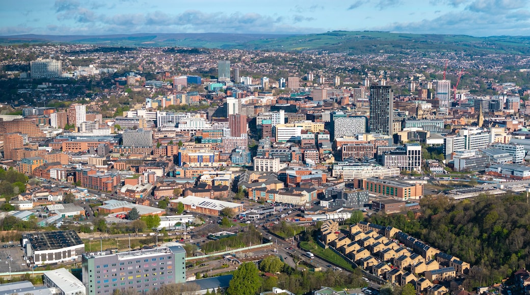 A cityscape with a mix of modern and older buildings, a river, and surrounding hills.
