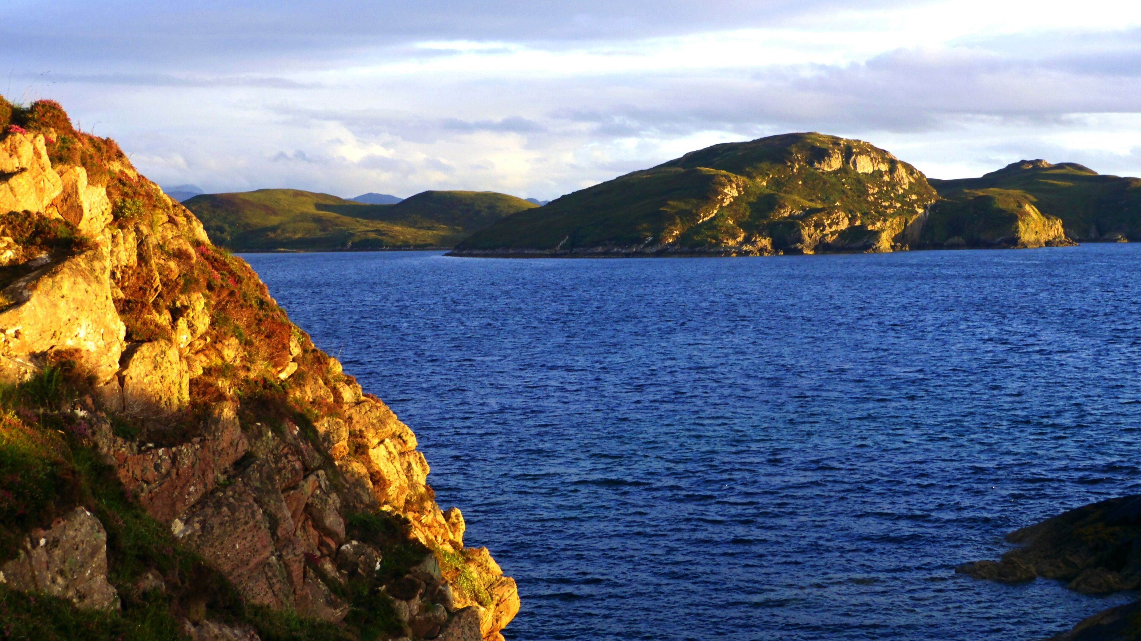 A coastal landscape with rocky cliffs and calm sea.