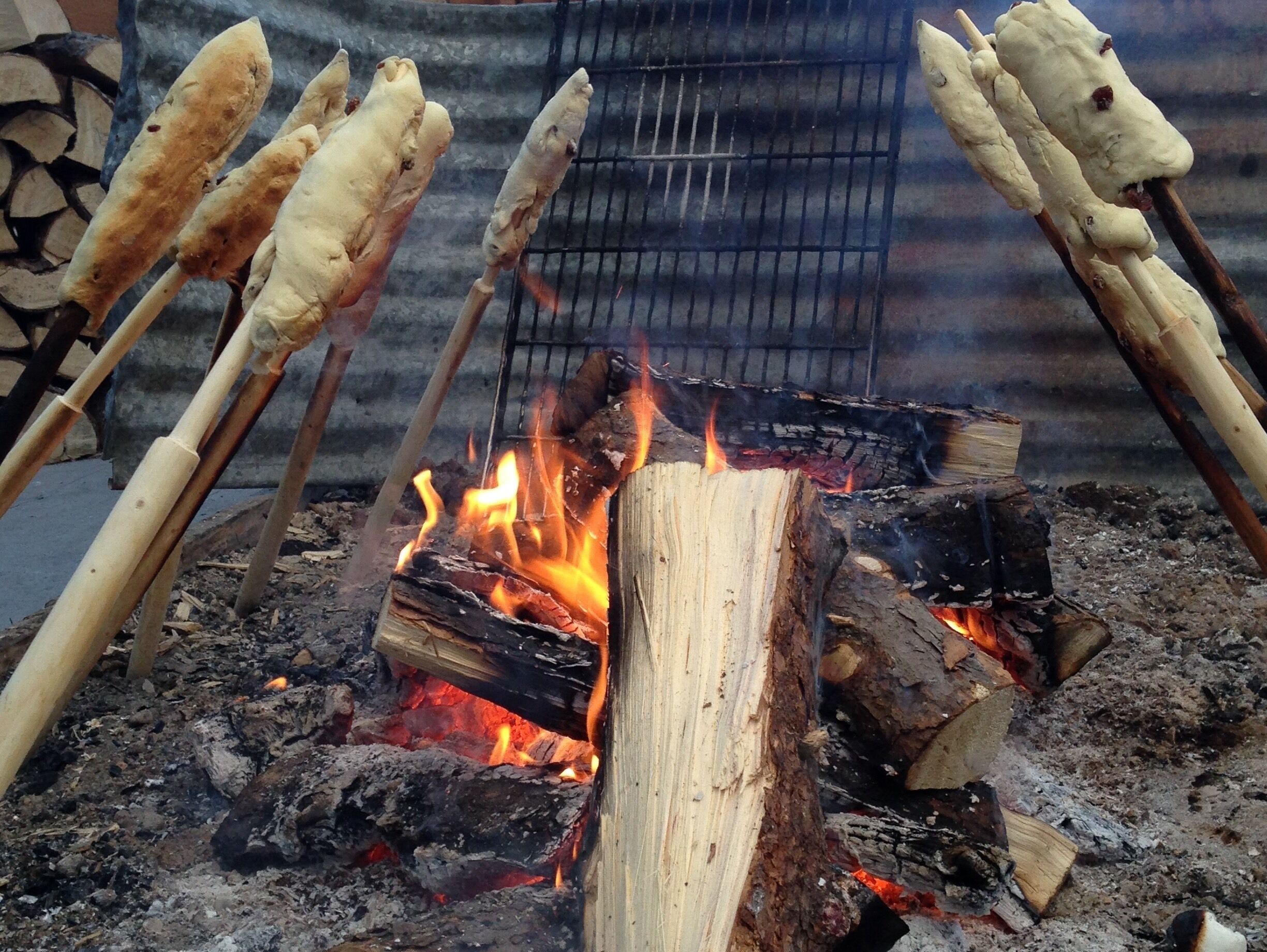 A campfire with several marshmallows on sticks.