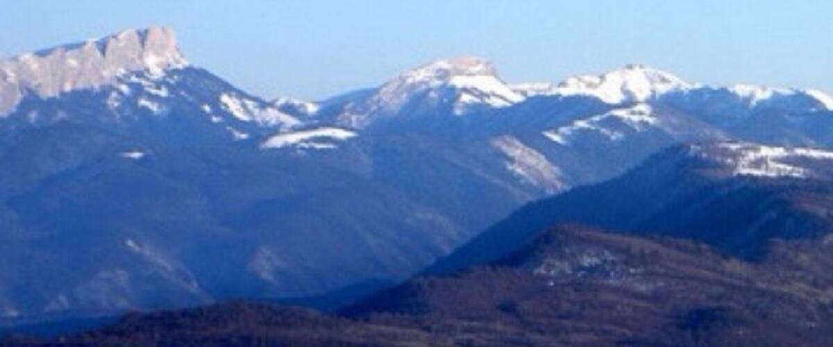 A mountain range with snow-capped peaks and a clear sky.