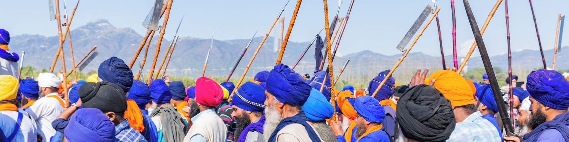 #Blue. This image is from Hola Mohalla, a tradition of annual celebration of valour started by Sikh Guru, Guru Gobind Singh. This celebration happens in Anandpur Sahib, a small town in the northern Indian state of Punjab. The procession of sharp-edged weapon wielding Nihang Sikhs is completely peaceful. The show-stopper of this festivity is show riding - daredevil riders ride 3 or even 4 galloping horses standing upright holding the reigns in their mouth.