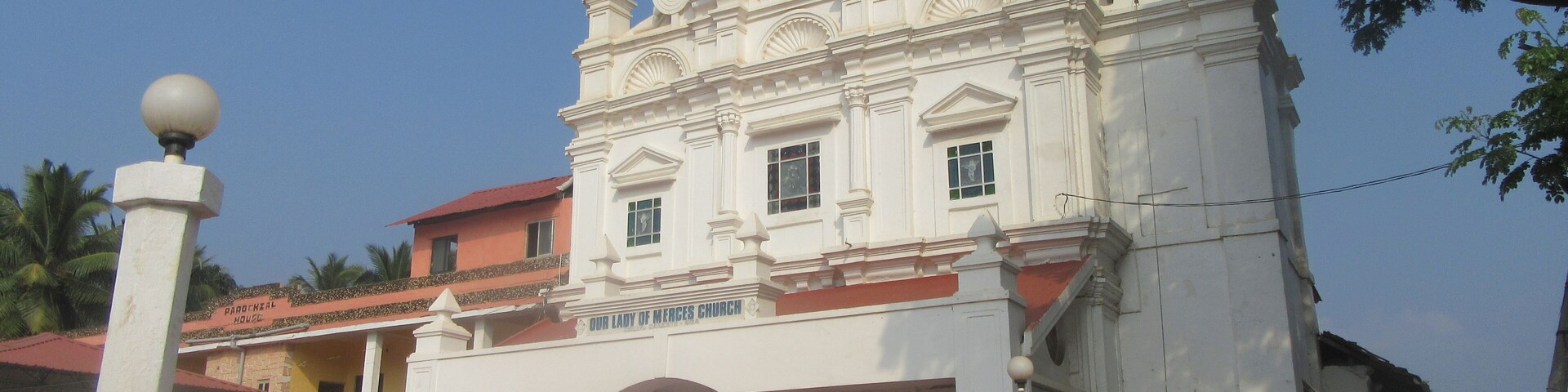 Igreja de Nossa Senhora da Misericórdia com fachada branca, telhado vermelho e um campanário.