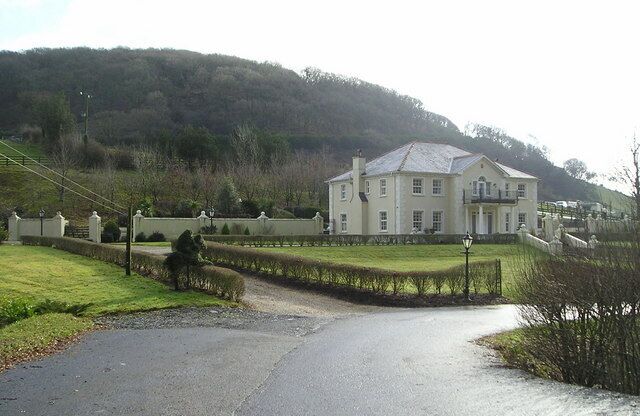 Felinfach Modern mansion with racing stables, just visible beyond, and a racetrack, out of view. Did you notice the topiary, a bush cunningly crafted to look like a horse with jockey leaping the hedge?