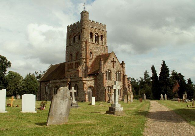 A church with a tall tower and a graveyard with headstones.