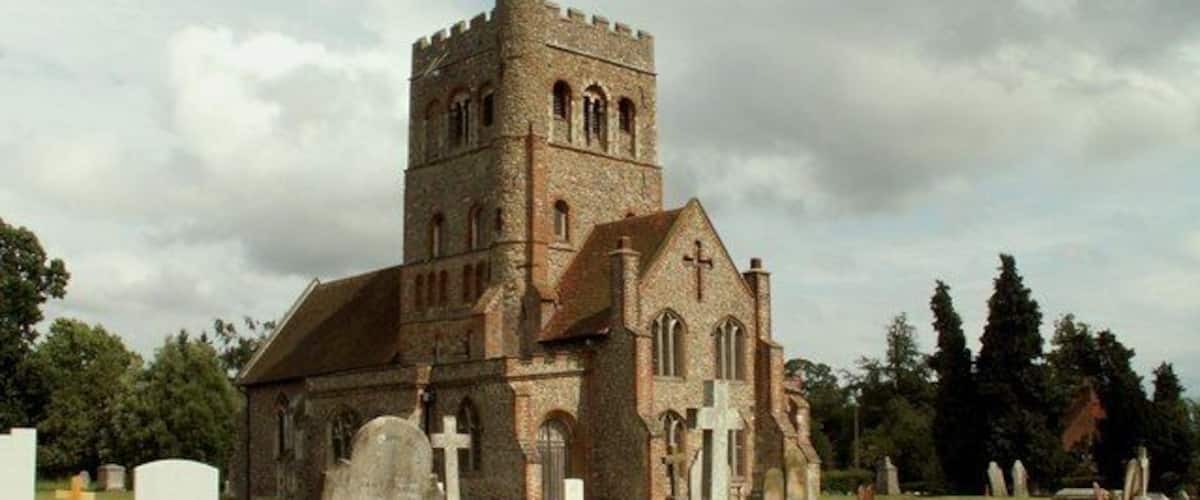 A church with a tall tower and a graveyard with headstones.
