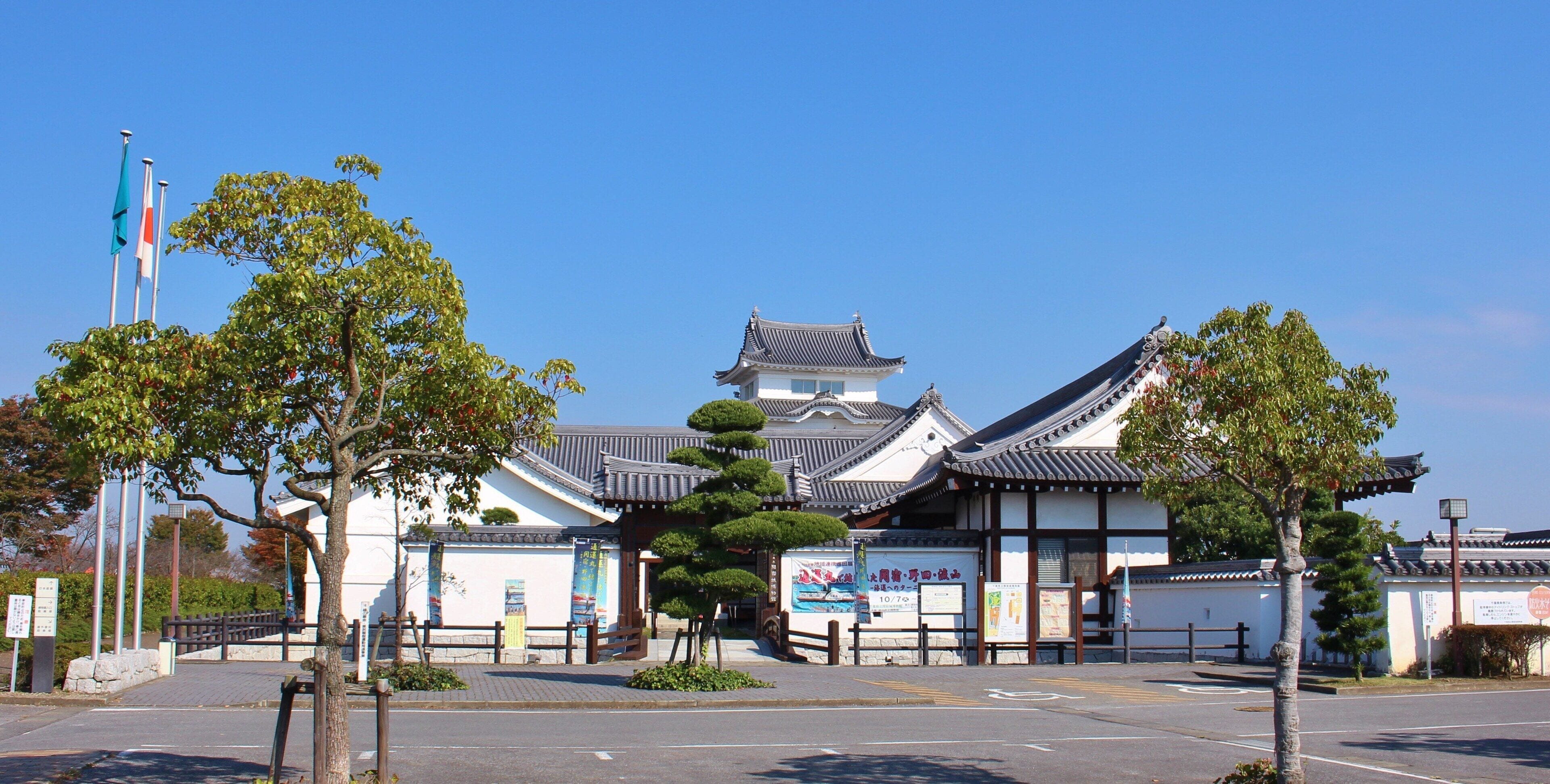 A traditional Japanese building with a tiled roof and white walls.