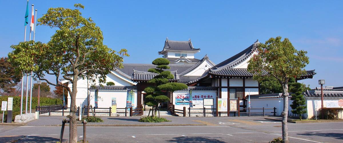 A traditional Japanese building with a tiled roof and white walls.