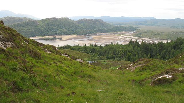 A valley with a river, forested hills, and distant mountains.