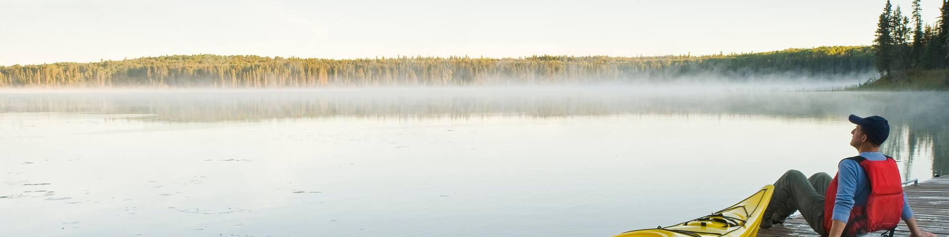 man and kayak on dock, Hanging Heart Lakes, Prince Albert National Park, Saskatchewan, Canada