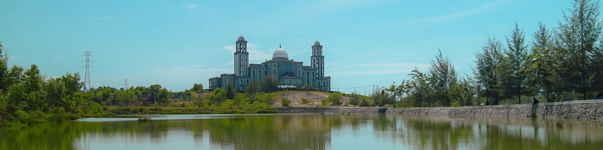 This magnificent building resembling a dome and a mosque in an empty field with an artificial lake above is the regional government office of Idi Rayeuk, East Aceh, Indonesia
