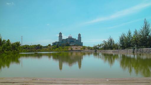 This magnificent building resembling a dome and a mosque in an empty field with an artificial lake above is the regional government office of Idi Rayeuk, East Aceh, Indonesia