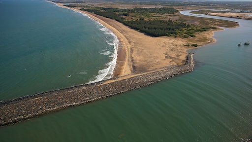 Aerial view of the tranquil coastline where the shimmering sea meets the sandy shore near Karaikal Beach, Karaikal, Puducherry, India.