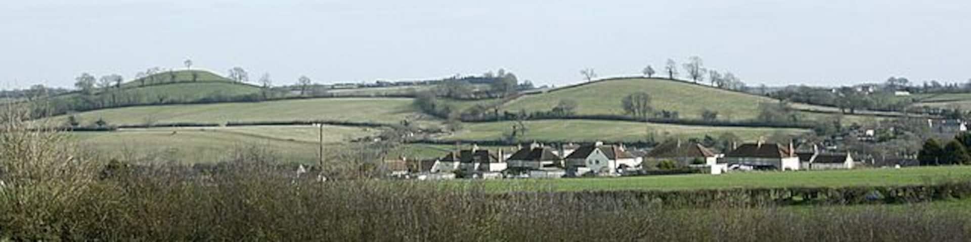 Farmborough from Marksbury Plain Good pastureland. The hill with the lone tree on top is known as Farmborough Common and is a well known landmark in the area being visible from north and south.