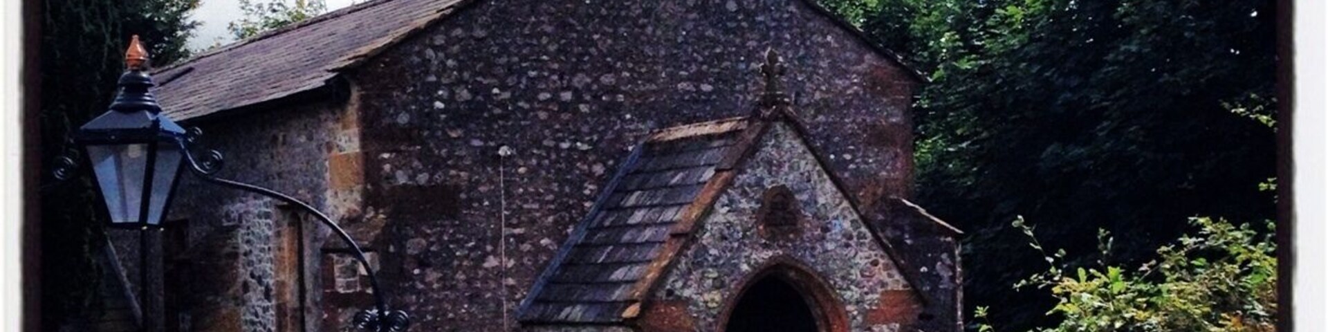 Una iglesia histórica con un campanario y un letrero en la entrada.