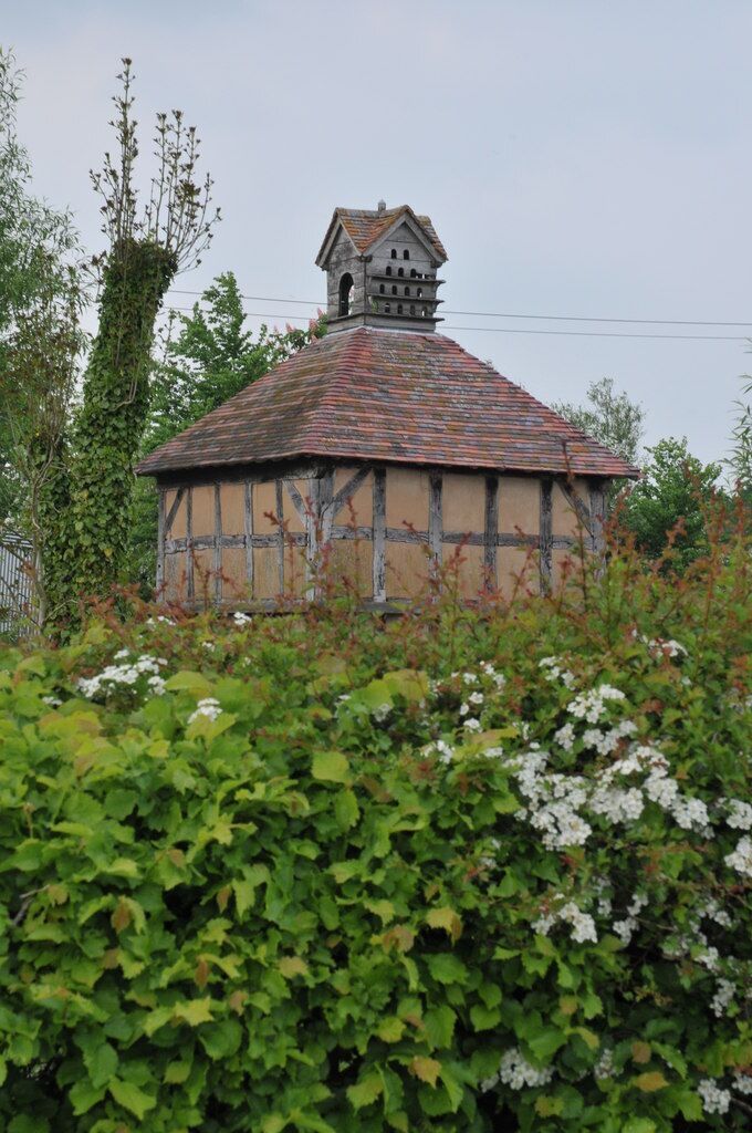 A traditional half-timbered house with a tiled roof and a bell tower.