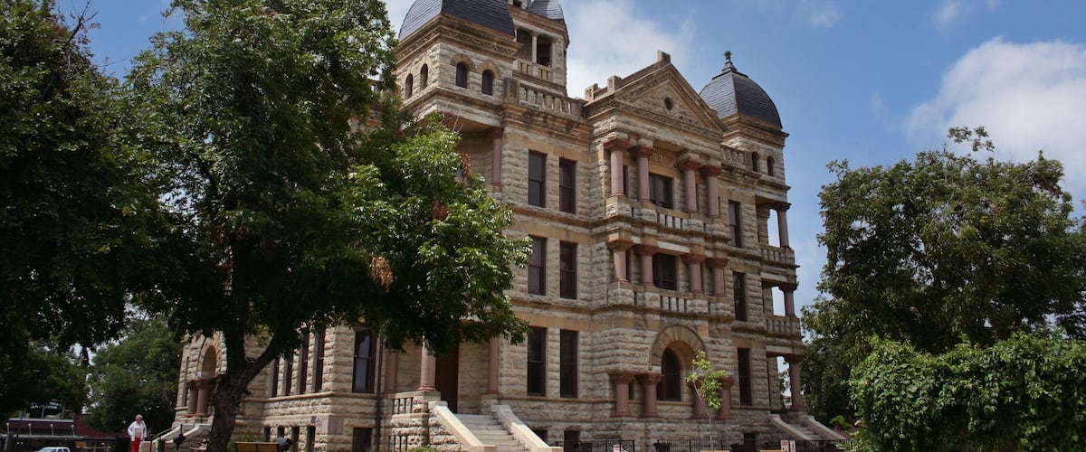 A large stone building with multiple domes and a clock tower.