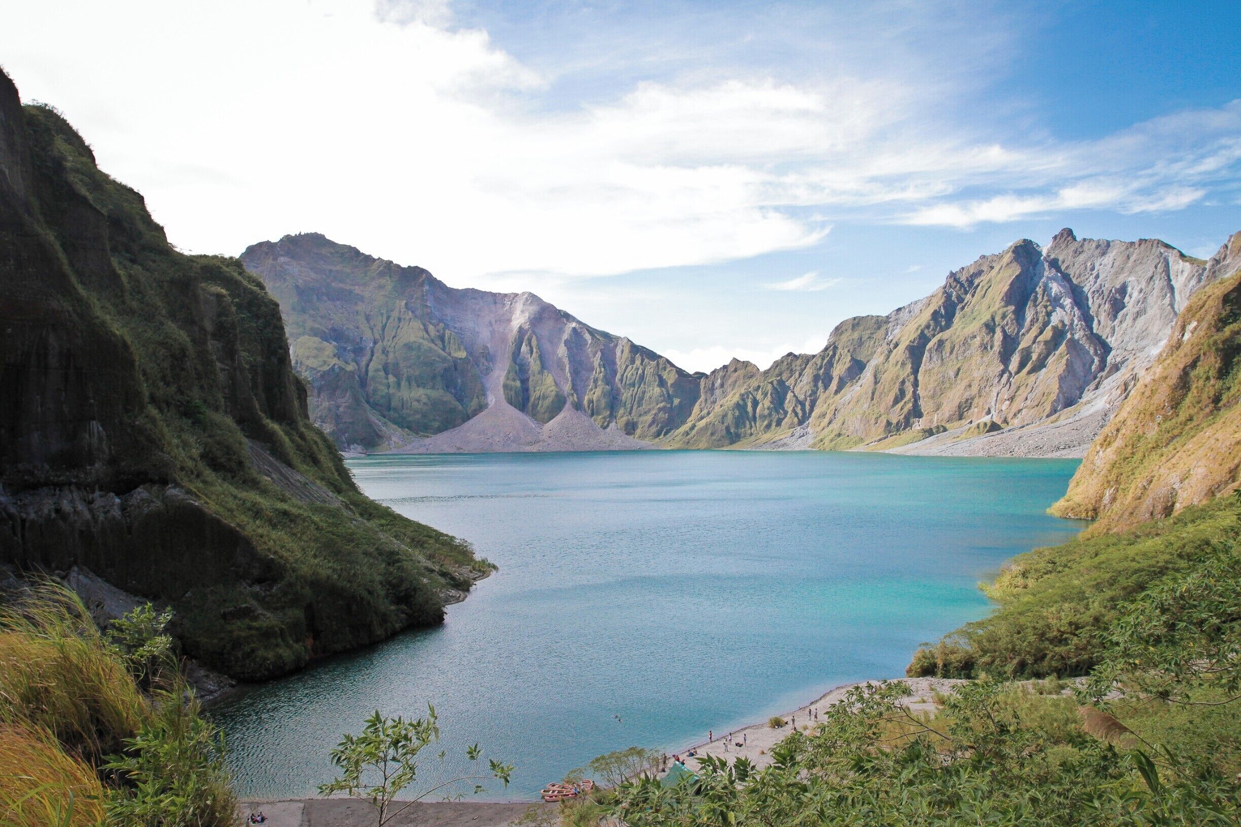 A mountainous landscape with a calm lake surrounded by steep cliffs.