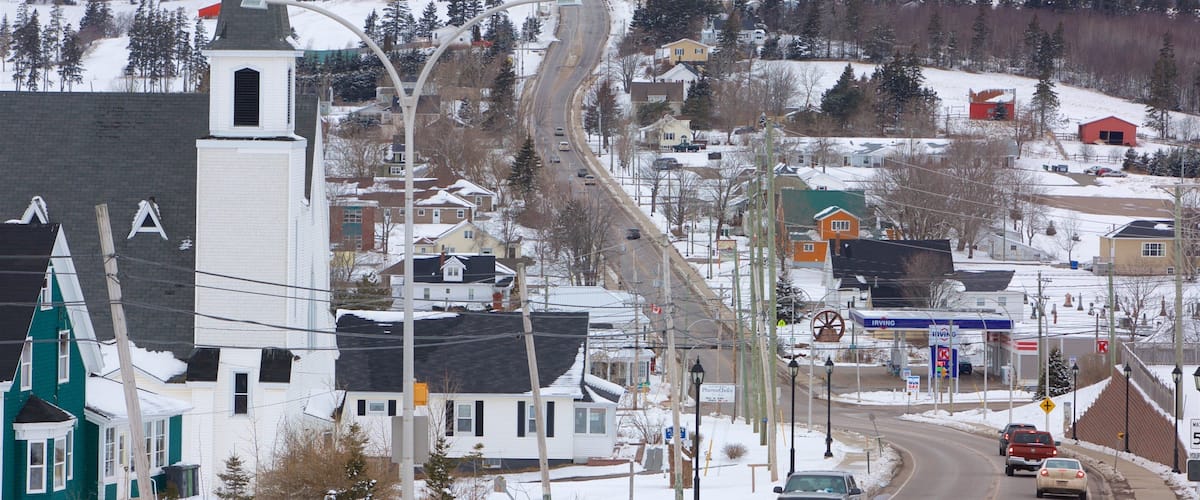 A snowy town with a church, a winding road, and a gas station.