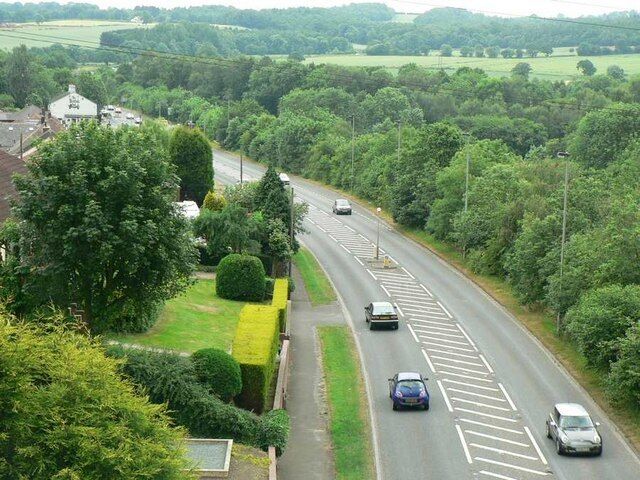 Denby Dale Road, Calder Grove. Looking down from the disused railway viaduct which crosses the road, and a railway line. The white building at the left is The British Oak, a pub at the corner of Blacker Lane. See also 193164