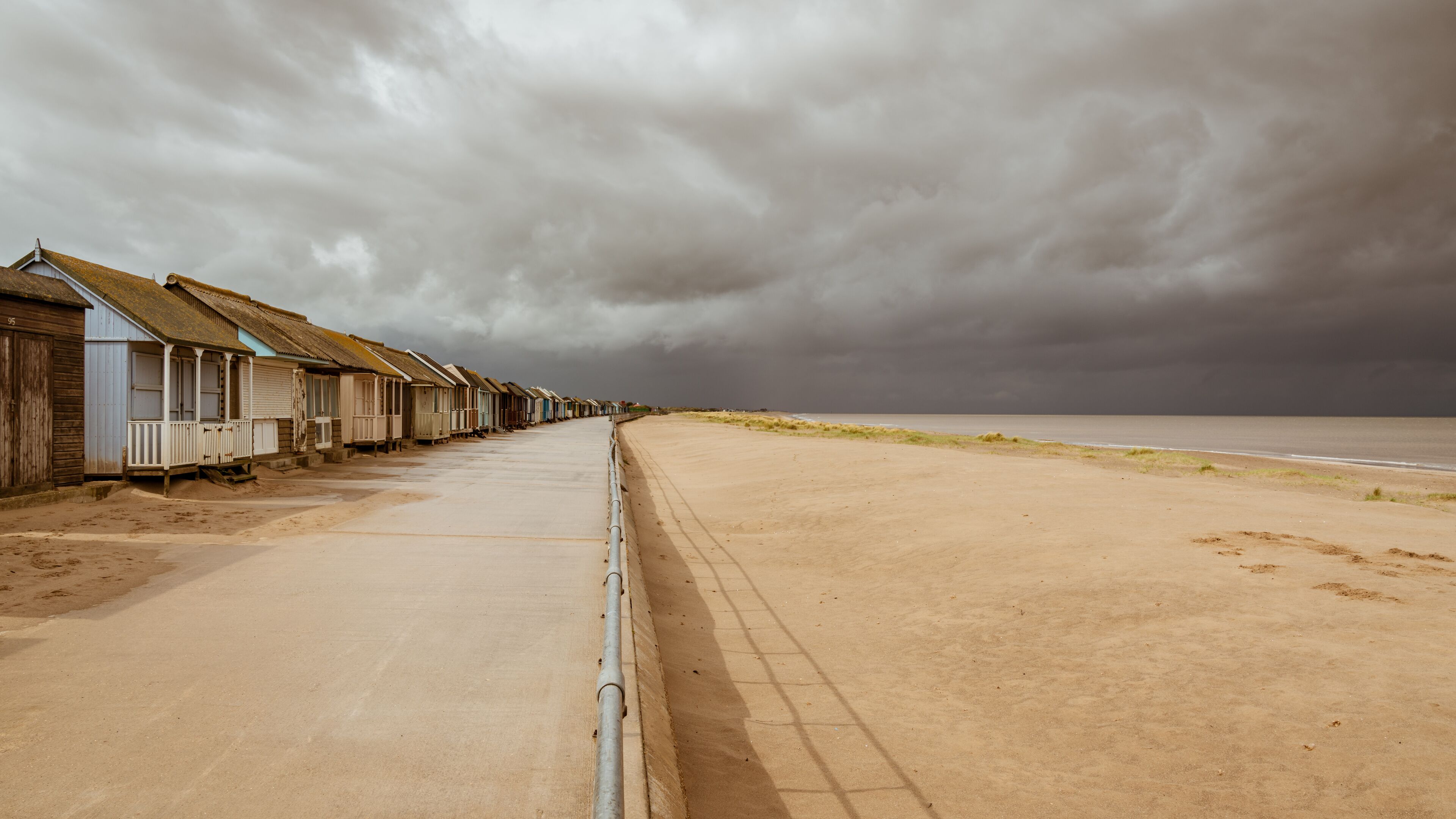 Grey clouds over the Beach Huts in Sandilands, Lincolnshire, England, UK