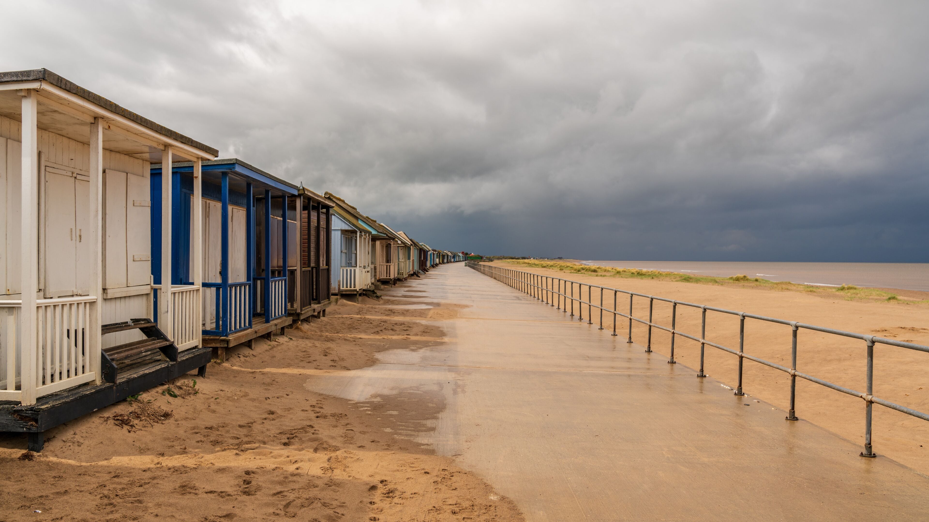 Grey clouds over the Beach Huts in Sandilands, Lincolnshire, England, UK