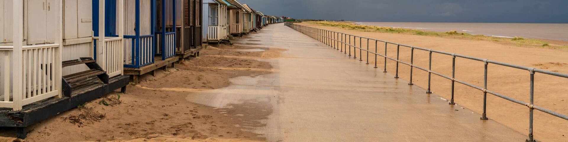 Grey clouds over the Beach Huts in Sandilands, Lincolnshire, England, UK