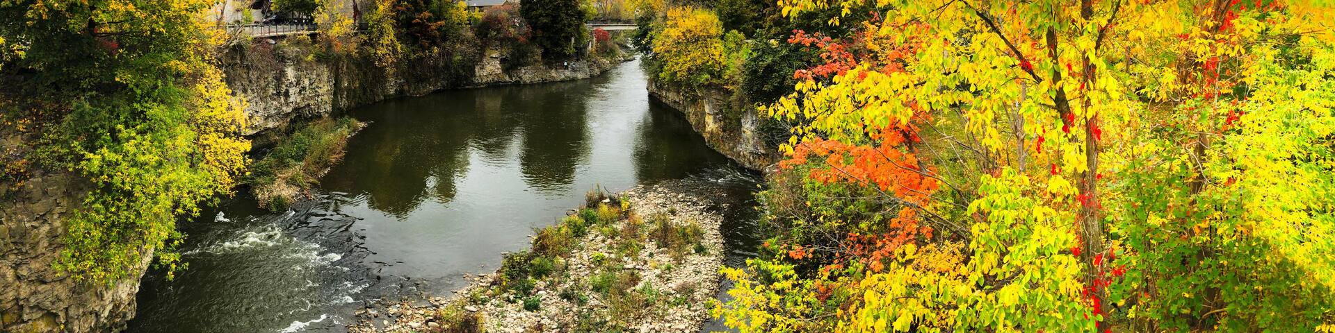 A river flowing through a rocky gorge with autumn foliage.