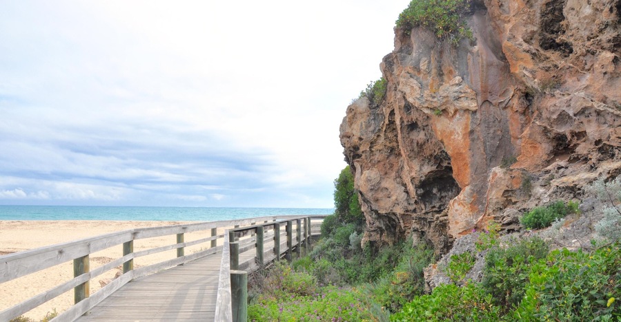 GAWFGE Boardwalk with rugged limestone formations at the Moore river mouth to the Indian Ocean in Guilderton, Western Australia.
