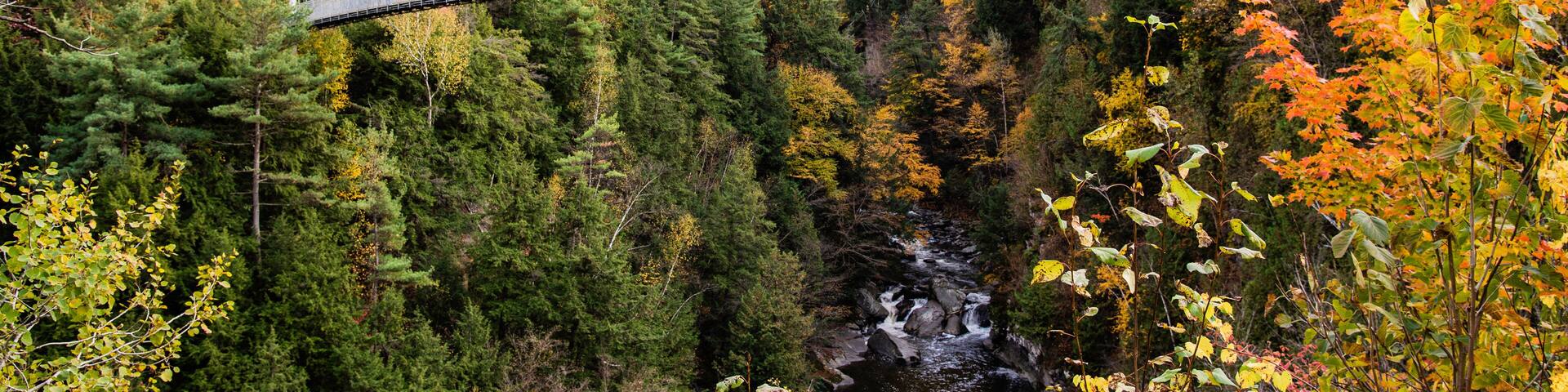 Coaticook, Canada - Oct. 12 2024: Suspension Bridge in Colorful autumn season in Parc de la Gorge