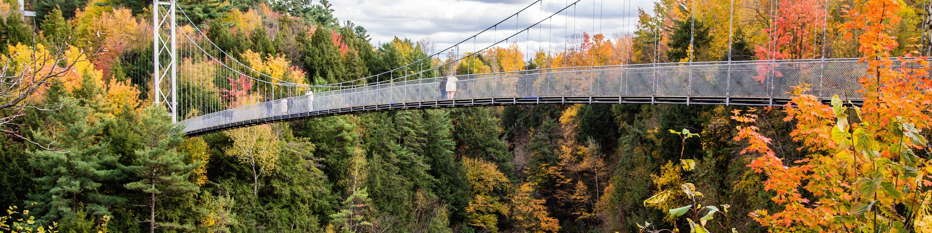 Coaticook, Canada - Oct. 12 2024: Suspension Bridge in Colorful autumn season in Parc de la Gorge