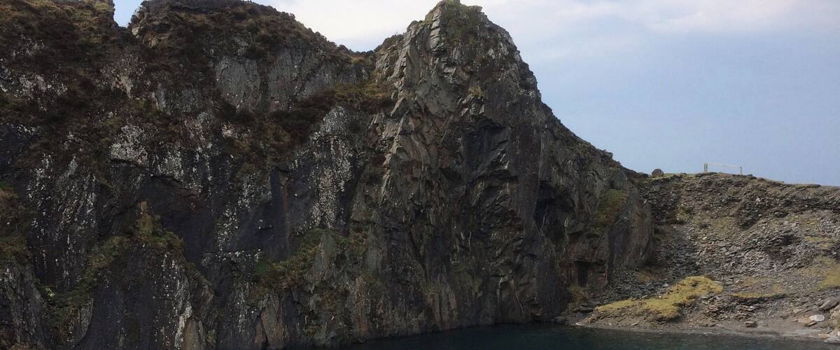 A rocky coastline with a calm lake.