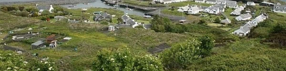Easdale. Seen from the islands only remaining high ground at 124 feet. Ellenabeich to the left.