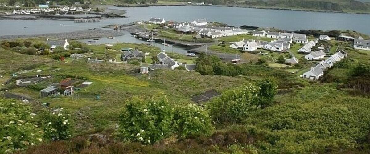 Easdale. Seen from the islands only remaining high ground at 124 feet. Ellenabeich to the left.