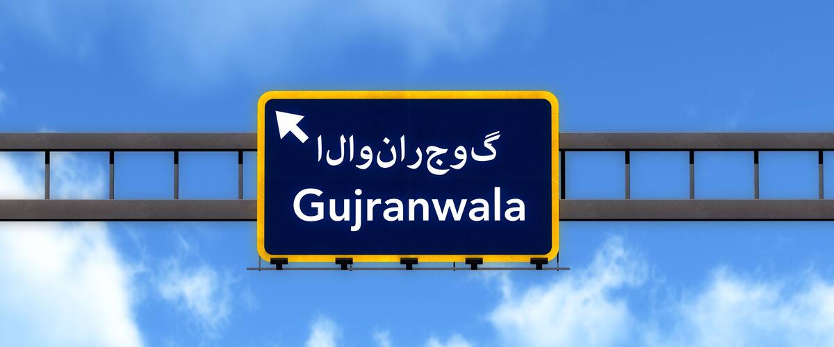 A road sign with the text "Gujranwala" and an arrow pointing to the right.