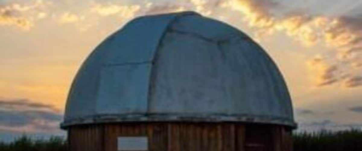 A wooden observatory with a dome roof.