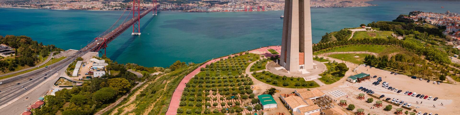 Aerial view of Sanctuary of Christ the King, Santuario de Cristo Rei. Lisbon, Portugal. Drone photo at sunrise with the 25 de Abril Bridge in background