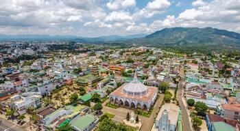 A cityscape with a prominent church and mountains in the background.
