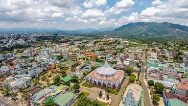 Aerial view of ancient Phuoc Hue pagoda is next to Bao Loc church on summer's day in Bao Loc, Vietnam, peaceful small town located on the plateau Di Linh, Lam Dong province.