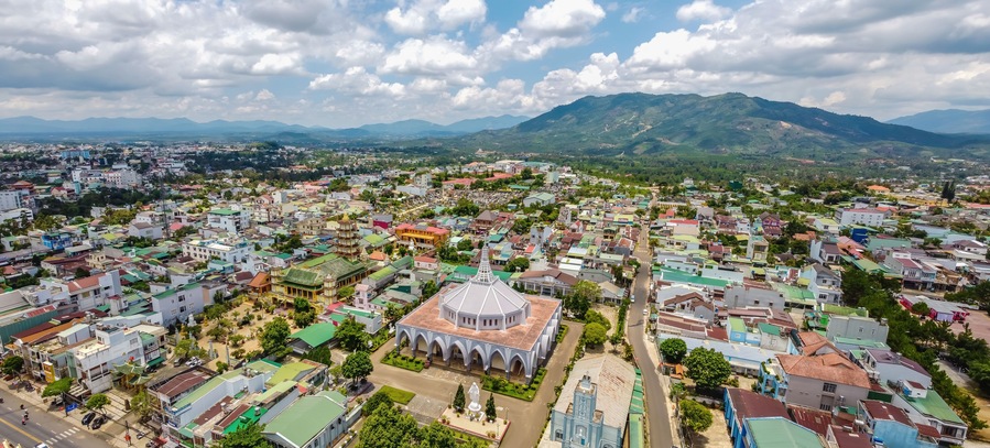 Aerial view of ancient Phuoc Hue pagoda is next to Bao Loc church on summer's day in Bao Loc, Vietnam, peaceful small town located on the plateau Di Linh, Lam Dong province.