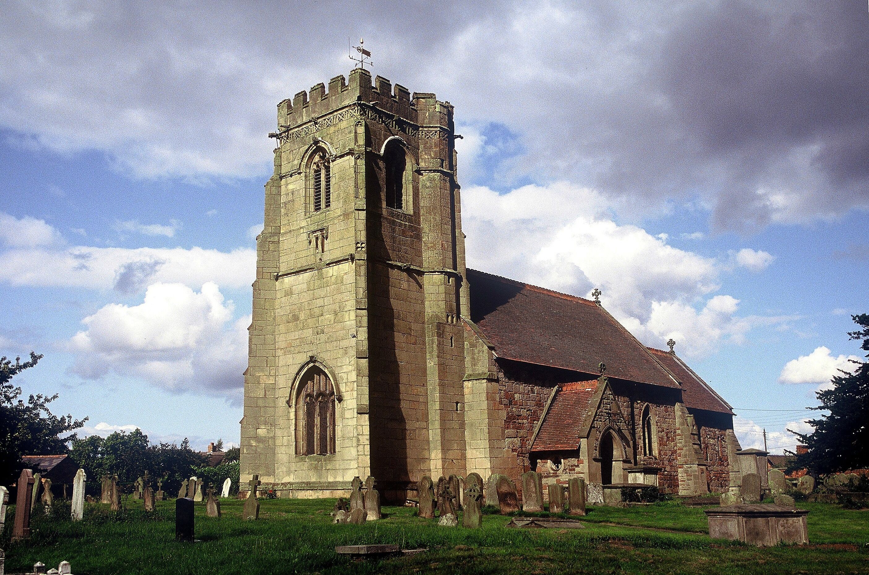 A historic church with a tall tower and a large arched window.