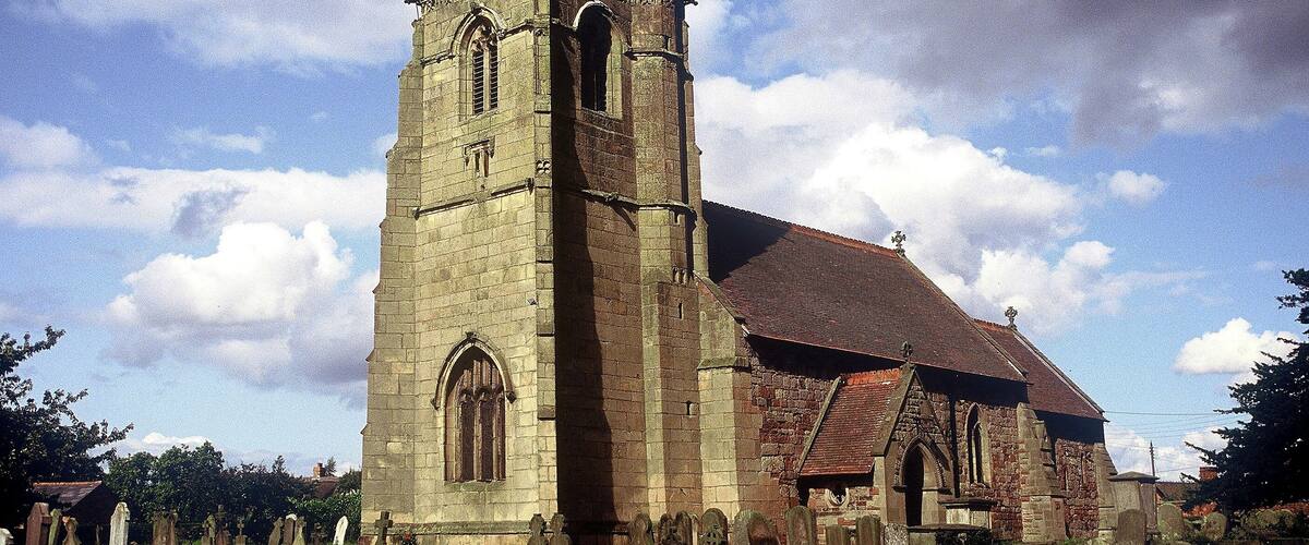 A historic church with a tall tower and a large arched window.