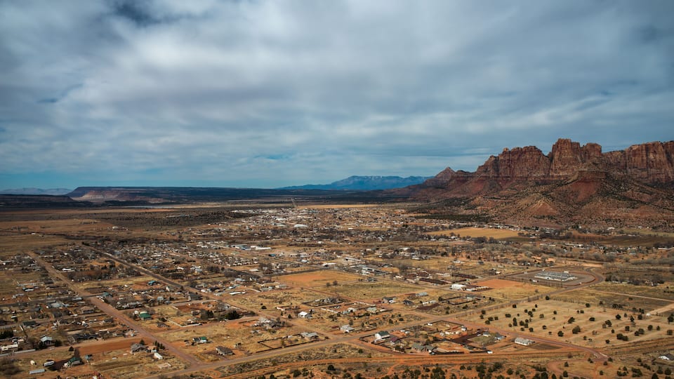 An aerial view of a town with a mountainous backdrop.