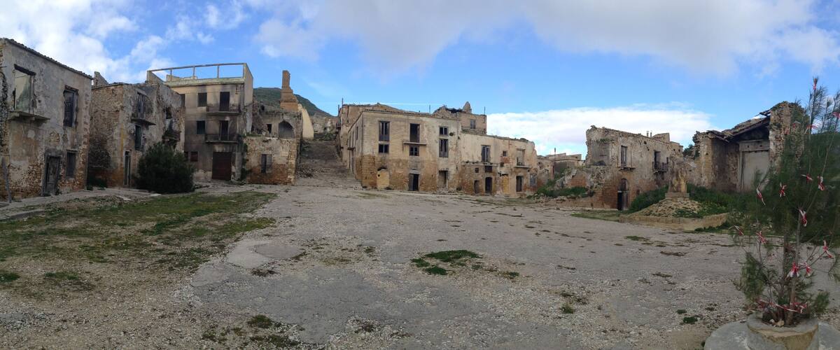 A deserted street with dilapidated buildings and a clear sky.