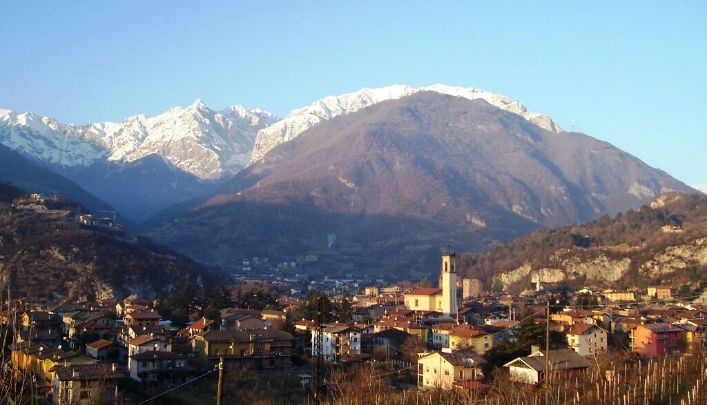 A town nestled between mountains with snow-capped peaks in the background.